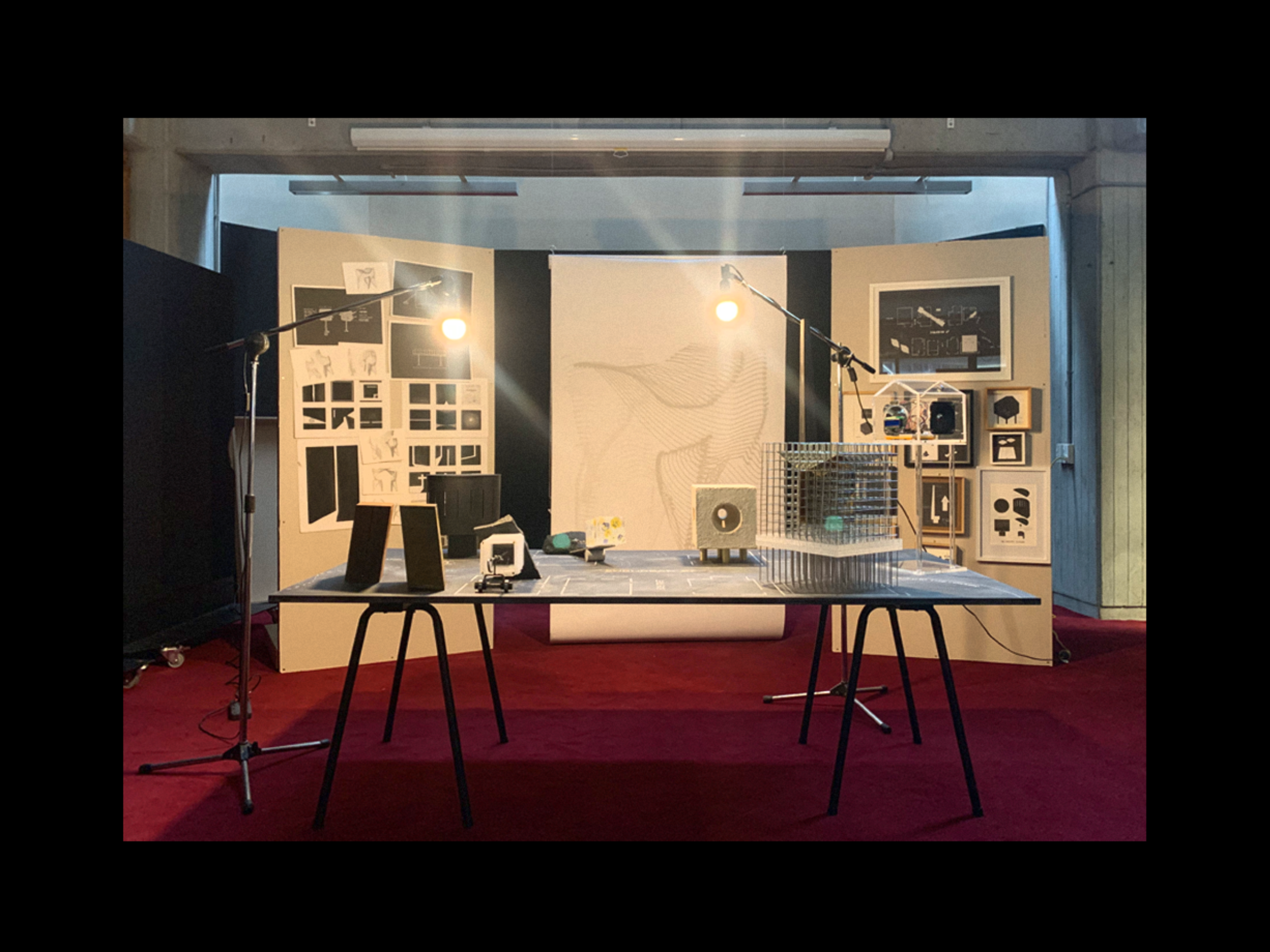 Set up of the mid-year critique, which experimented with different tupes of media, installation elements and narrative performance. Set up includes faux walls displaying the Light Images, Boxed Drawings, Machine Diagrams and blueprints of the artifacts and counter-artifacts; a 1:1 Light Image displayed as a blind over a window; and the streetscape tabletop with artifacts and counter-artifacts.